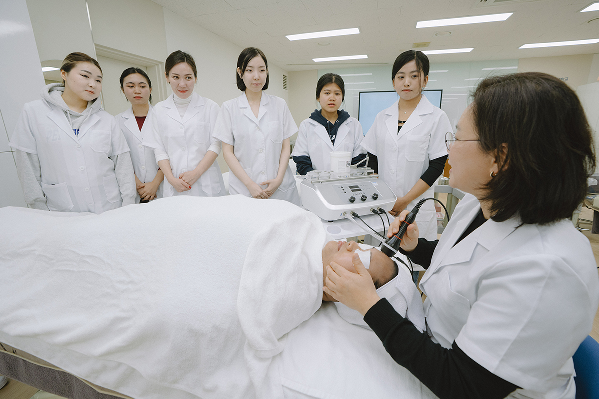 교수님께 미용실습을 지도받는 학생들